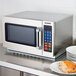 A silver Solwave 180PEDOOR microwave on a counter with a sandwich inside.