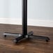 A black metal table leg on a wood floor.