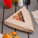 A Bagcraft corrugated pizza box with a window holding a slice of pizza next to a fork and chips.