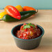 A bowl of salsa with a jalapeno garnish.