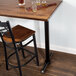 A Lancaster Table & Seating black cast iron bar height end column table base with self-leveling feet.