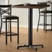 A Lancaster Table & Seating black cast iron bar height table base with FLAT Tech levelers.