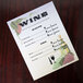 An 8 1/2" x 11" menu paper with a grapevine design, wine bottles, and grapes on it.