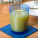 A close up of a Cambro Del Mar Sapphire Blue plastic tumbler filled with orange juice on a table