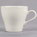 A close-up of the handle of a Tuxton Europa eggshell white cappuccino mug.