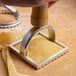 A hand using the Fox Run Ravioli Cutter Stamp to cut dough into squares.