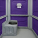 A PolyJohn wheelchair accessible portable restroom in a purple room.