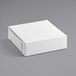 A white cardboard bakery box with brown trim.