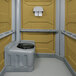 A tan PolyJohn wheelchair accessible portable restroom with a toilet seat.