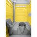 A PolyJohn yellow portable toilet with a translucent top.