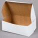 A white cake box with a brown lid.