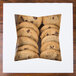 A pile of chocolate chip cookies in a white bakery box with a window.