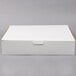 A close-up of a white 19" x 14" x 4 1/2" half sheet cake box with a lid.