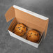 A white jumbo muffin box with two muffins inside.
