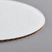A Baker's Mark white corrugated circular cake circle with a circular cut out in the middle.