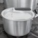 A Vollrath Wear-Ever aluminum pot cover with a black and white Torogard handle on a pot.