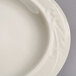 A close-up of a Homer Laughlin ivory china plate with a curved edge.