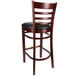 A Lancaster Table & Seating mahogany wood bar stool with a black vinyl seat.