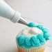 A cupcake with blue frosting piped with an Ateco left-handed curved petal tip.
