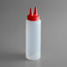 A white plastic squeeze bottle with a red lid.
