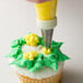 A person using an Ateco drop flower piping tip to decorate a cupcake.