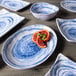 A close up of a plate of blood oranges on a white and blue Elite Global Solutions Van Gogh melamine plate.