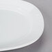 A close-up of a CAC rectangular white porcelain platter with a wavy edge.