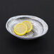 An Elite Global Solutions oval melamine bowl with lemon slices in it.