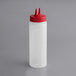 A clear Vollrath Twin Tip squeeze bottle with a red cap.