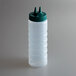 A clear plastic Vollrath Twin Tip squeeze bottle with a green cap with two pointy tips.