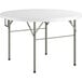 A Lancaster Table & Seating white round heavy-duty plastic bi-folding table with metal legs.
