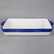 A white and blue rectangular Tuxton casserole dish with cobalt bands.