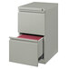 A gray Hirsh Industries mobile pedestal file cabinet with a drawer open and red files inside.