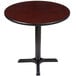 A Lancaster Table & Seating round table with a black base and reversible cherry/black top.