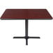 A Lancaster Table & Seating table with a black base and a reversible cherry/black top.