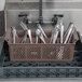 A Noble Products brown flatware rack with spoons in it.