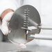A person in white gloves using a Nemco Curly Fry Cutter separating blade.