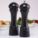 Two black Chef Specialties Windsor salt and pepper shakers on a table.