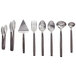 American Metalcraft 8-Piece Wavy Aged Stainless Steel Buffetware Utensils set on a table with serving utensils.
