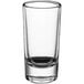 A clear shot glass with a black bottom.