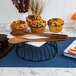 A tray of muffins on a table with the American Metalcraft Hammered Bronze Vintage Tongs.
