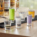 A table with several Acopa shot glasses filled with purple liquid.