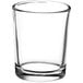 A clear glass Acopa shot glass with a curved rim.