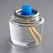 A clear glass jar with a blue lid and two yellow tubes inside.