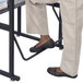 A person standing at a Safco AlphaBetter desk with their feet on the footrest.
