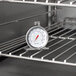 A Taylor oven thermometer on a rack in the oven.