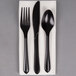 A white linen-like napkin with a pre-rolled black heavy weight plastic cutlery set.