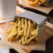 Tablecraft stainless steel fry cup filled with french fries.