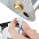 A hand uses a plastic tool to remove the metal shaft bearing.