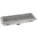 A stainless steel Advance Tabco floor trough drain with a metal grate.